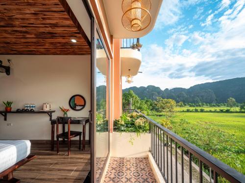 a room with a balcony with a view of a field at Tam Coc Haven House in Ninh Binh