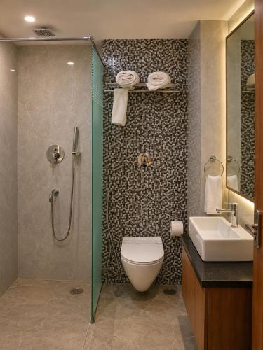 ein Badezimmer mit Dusche, Toilette und Waschbecken in der Unterkunft HOTEL ABHIJIt in Kolaghat