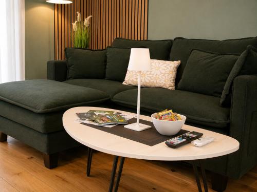 a living room with a green couch and a table at Haus Madeleine in Schönwald
