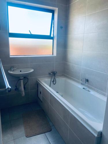 a bathroom with a bath tub and a sink at Number 8 in Maseru