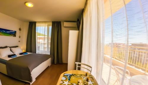 a bedroom with a bed and a large window at William's apartments - second cozy studio in Sveti Vlas