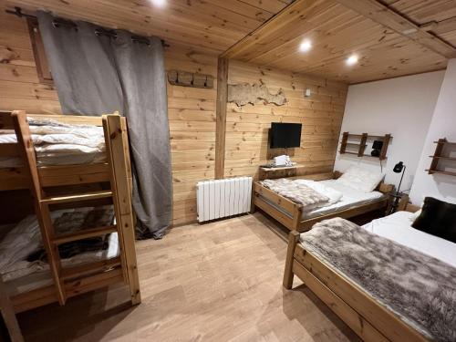a room with two bunk beds and a television at Le Chalet d’Andrea in Vars
