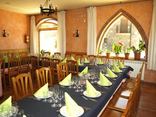 a dining room with a long table with yellow napkins at El Churrón in Larrés