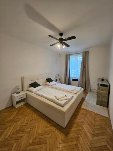 a bedroom with a large bed with a ceiling fan at 2 bedroom apartment, near Xbionic in Šamorín