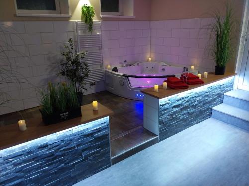 a bathroom with a tub with candles and a bath tub at Wellness apartmány Puštík se soukromou vířivkou a saunou in Pěnčín
