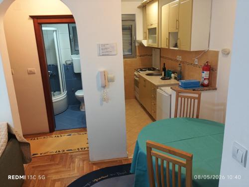 a kitchen with a table and a sink and a toilet at Apartment Grandis in Škaljari