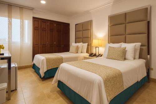 a hotel room with two beds in a room at Hotel Windsor Barranquilla in Barranquilla