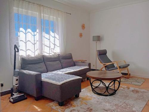 a living room with a couch and a table and a chair at Great for Families in Lourinhã-Double Rooms-Private Baths-Free Parking & Extra Bed in Lourinhã