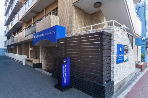a building with a blue sign on the side of it at HOTEL MYSTAYS Ueno Inaricho in Tokyo