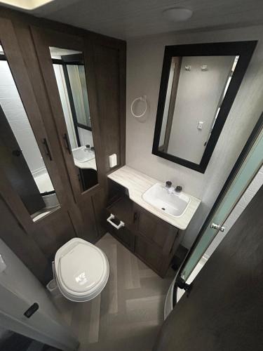a bathroom with a toilet and a sink and a mirror at Rocking Horse Stables in Altoona