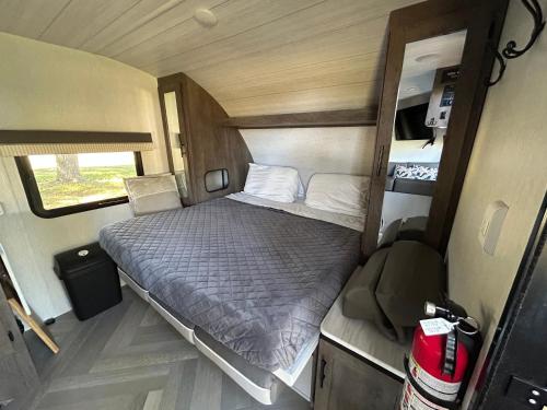 a small bedroom with a bed in an rv at Rocking Horse Stables in Altoona