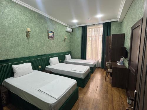 a hotel room with two beds and a television at Buta Hotel Berde in Bǝrdǝ