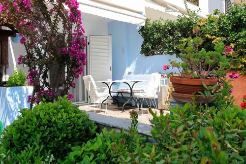 a patio with a table and chairs and flowers at FILIPPIDIS suites in Neos Marmaras