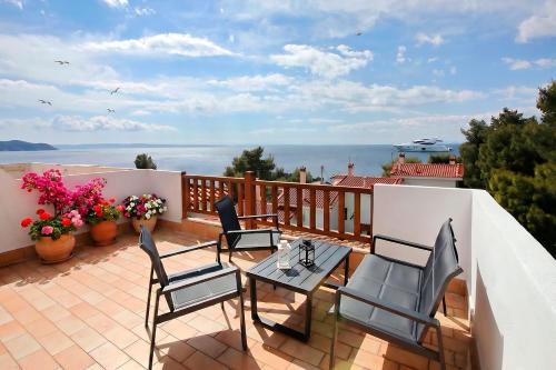 a patio with chairs and a table on a balcony at FILIPPIDIS suites in Neos Marmaras