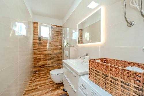 a bathroom with a sink and a toilet and a mirror at Apartment Anna - free private parking in Zadar