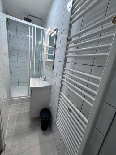 a white bathroom with a sink and a mirror at Petit cocon près des grottes de Perrier in Perrier