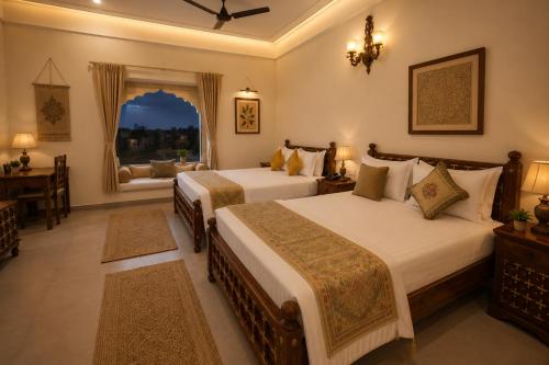 a hotel room with two beds and a window at Agastya Vilas Resort in Dhandni