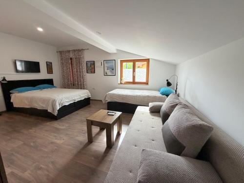 a living room with two beds and a couch at GuestHouse Flora in Koper