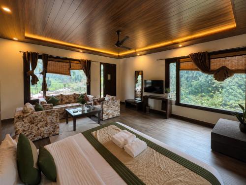 a living room with a couch and a table at Skywood by Vankuteer - Pool & Mountain view Rooms in Kandāghāt