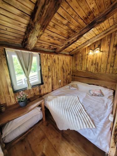 a bedroom with a bed in a wooden house at Cabana Noah Rustic in Vîlcăneşti