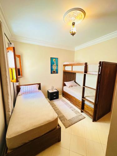 a room with two beds and a bunk bed at Vintage apartment EL JADIDA in El Jadida