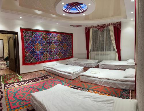 a room with four beds and a stained glass window at Marjan Guest House in Bokonbayevo