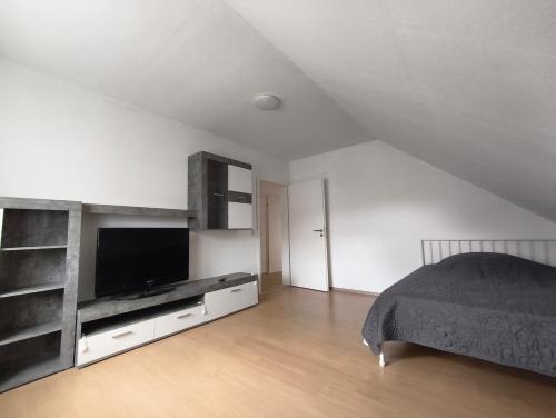 a bedroom with a bed and a flat screen tv at Monteurunterkunft nahe Münster in Drensteinfurt