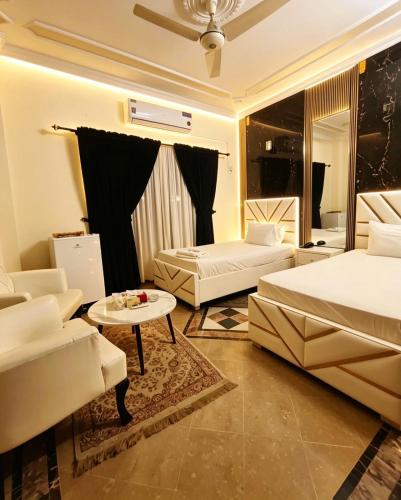 a hotel room with two beds and a table at Super Lodge by HFI in Islamabad