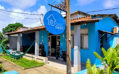 a blue house with a sign in front of it at Casa Swell Hostel in Fernando de Noronha