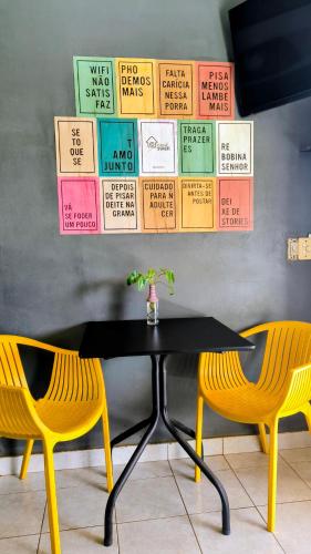 a table and two chairs with signs on the wall at Casa Swell Hostel in Fernando de Noronha