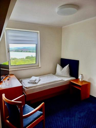 a small room with a bed and a window at Barbarossa Hotel Kelbra in Kelbra