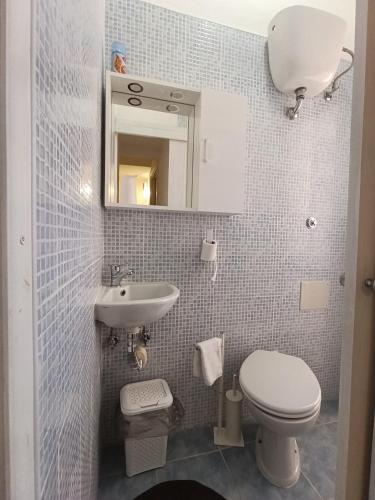 a small bathroom with a toilet and a sink at Casa Orchidea in Villasimius