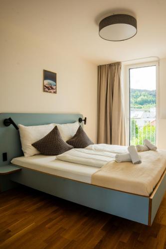 a large bed in a room with a window at Noas Bergisel in Innsbruck