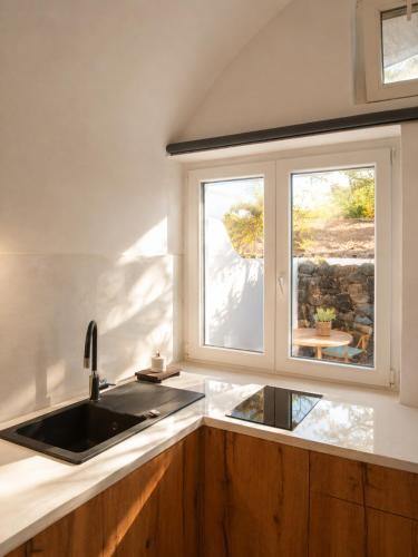 a kitchen with a sink and a window at Ecolodge Cave House in Vóthon