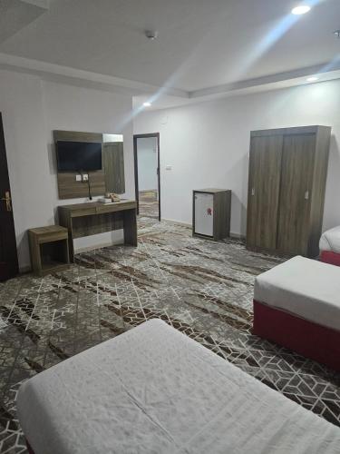a hotel room with two beds and a desk at فندق الراية الماسية in Mecca