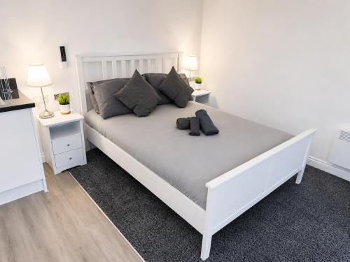 a white bed in a room with two night stands at The Studio Room in Brentwood
