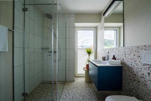 a bathroom with a shower and a sink and a toilet at Noas Bergisel in Innsbruck