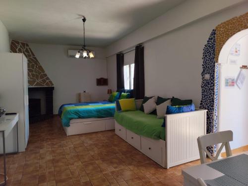 a bedroom with a bed and a couch in it at Studio Tropical in Cúllar-Vega