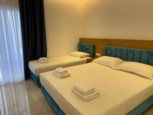 two beds in a hotel room with towels on them at Sorean HOTEL in Ksamil