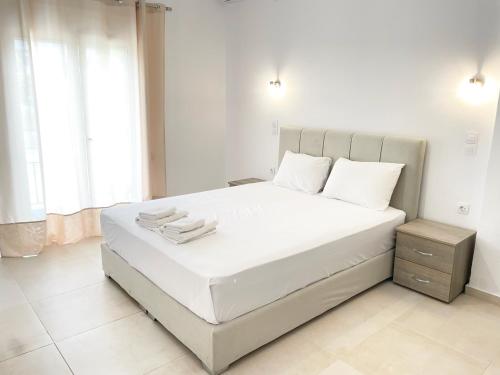 a bedroom with a white bed with white sheets and pillows at Κωνσταντίνος Έλενα Studios in Pefki