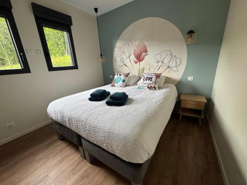 a bedroom with a bed with two towels on it at Pétalya Lodge in Montcornet