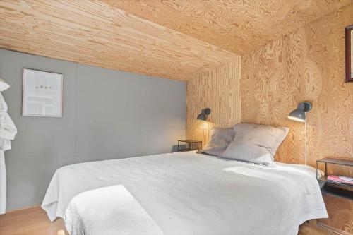 a bedroom with a white bed with a wooden ceiling at 1607-Vejby-Laerkebakken-8 in Vejby