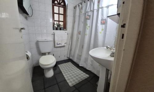 a small bathroom with a toilet and a sink at Día y noche in Ezeiza