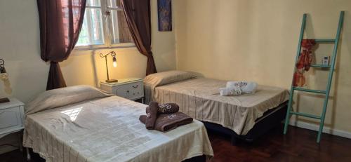 a room with two twin beds and a window at Día y noche in Ezeiza