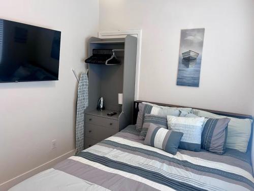 a bedroom with a bed and a television in it at Oceanside Getaway at Tuscan Village Condominiums in Oceanside