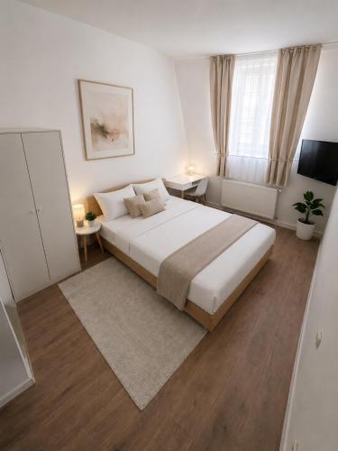 a bedroom with a large white bed and a window at Drava Osijek in Osijek