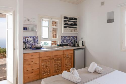 a kitchen with a sink and a counter with towels at Astarte Sifnos in Artemonas
