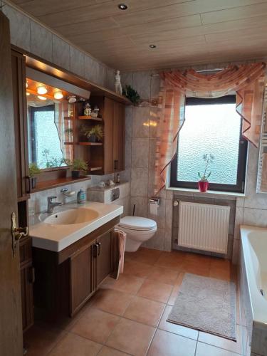 a bathroom with a tub and a sink and a toilet at Ferienwohnung Sonnenberg am Radweg in Gedern