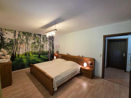 a bedroom with a bed and a painting on the wall at Ferienwohnung Sonnenberg am Radweg in Gedern