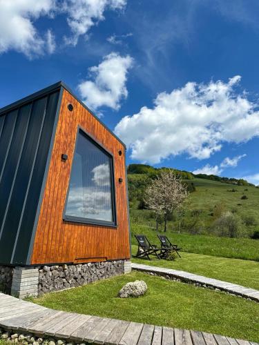 a house with a large window on the side of it at DANGUBA - Tiny Glamp House With Hot Tub by IGLENA in Kupres